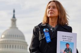 Woman holds a photo of her son outside of the capitol in Washington, D.C.